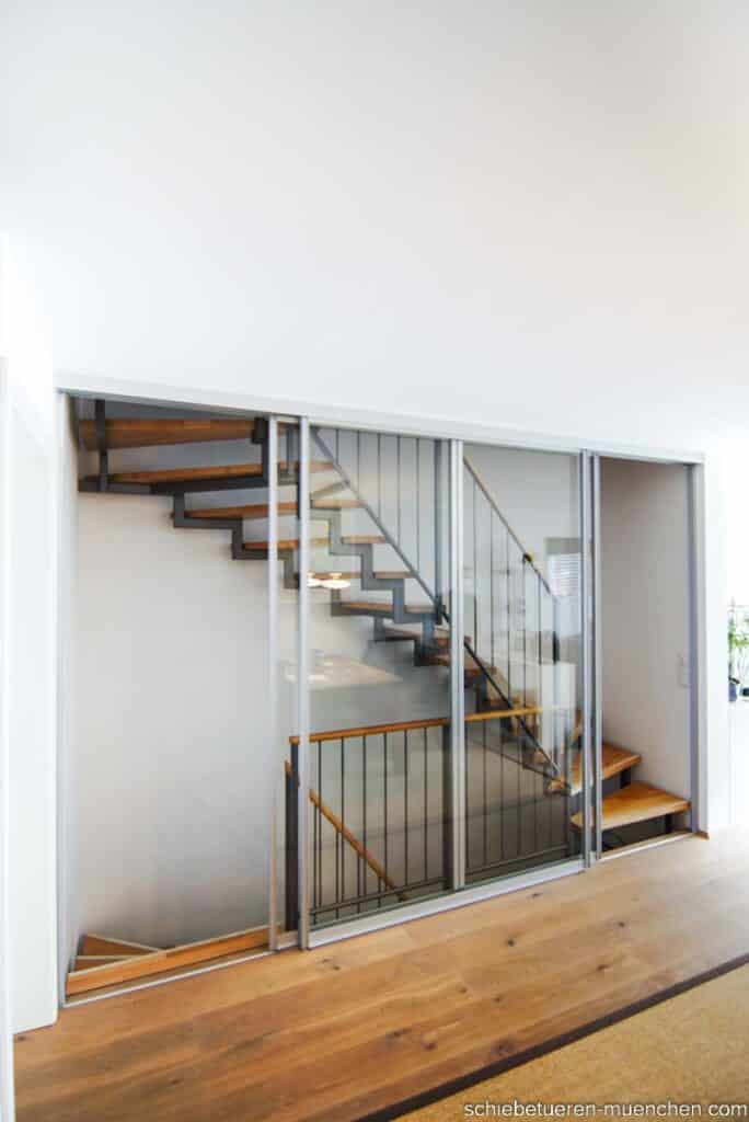 Breites, offenes Treppenhaus: Drei maßgefertigte Schiebetüren mit Anschlagsleisten sorgen für eine dichte Verschließung. Angefertigt von Door360 in München.