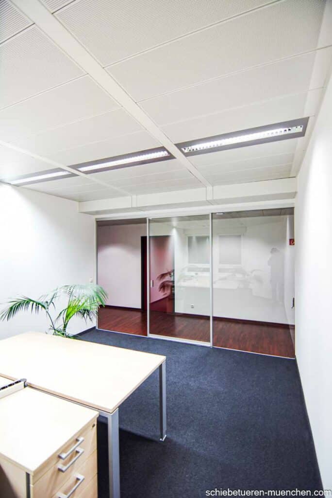In München wird eine dreimeterbreite Büronische durch eine Schiebetür und Festverglasung vom Flur abgetrennt.