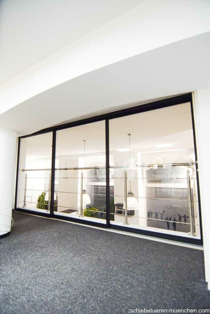 Abtrennung einer offenen Galerie in einem Büro in München: Schwarze Schallhemmende Klarglas-Schiebetüren.