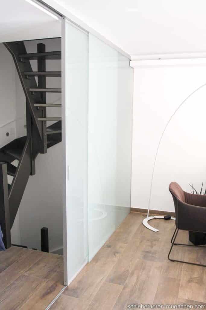 offenes Treppenhaus im ersten Stock wird durch eine Milchglas Festverglasung und einer Schiebetür bei Bedarf dicht verschlossen. individuell angefertigt von Door360 München