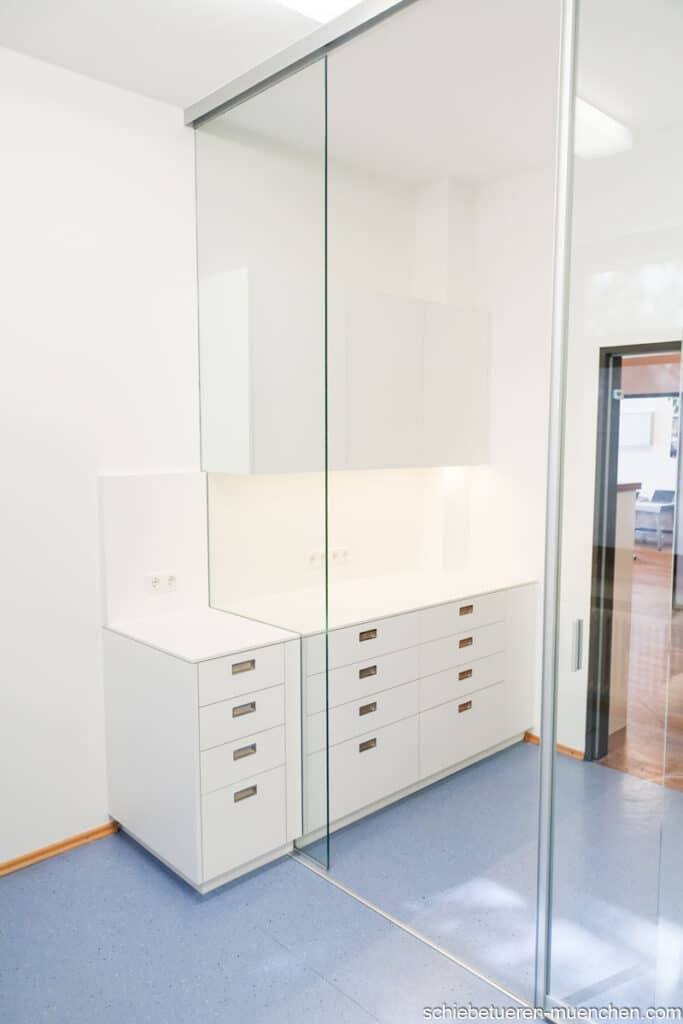 Raumteiler in einer Kombination von Festverglasung und Schiebetüren für einen Behandlungsraum in einer Arztpraxis in München