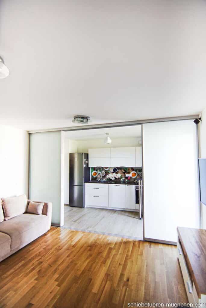 Ein Wohnzimmer kann durch vier Schiebtüren mit Milchglas Füllung von der Küche abgetrennt werden.