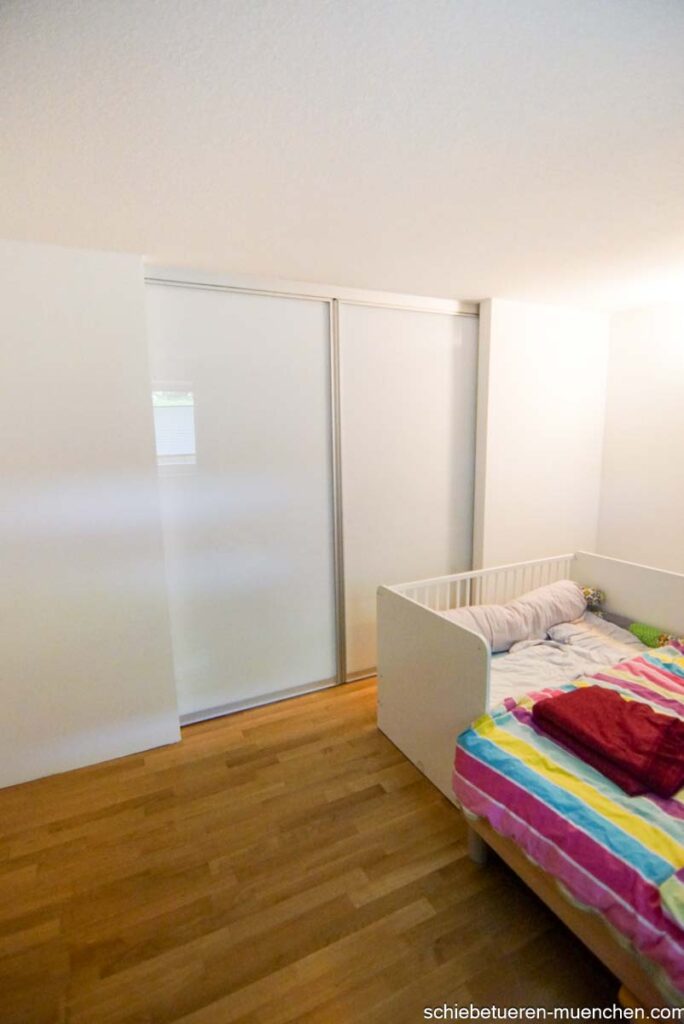 Milchglas-Schiebetüren verschließen einen großzügigen Durchgang zu einem Schlafzimmer in München und dienen als Raumteiler