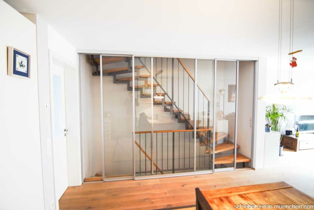 Ein offenes Treppenhaus in München mit Klarglas-Schiebetüren zur Abtrennung gegen Schall