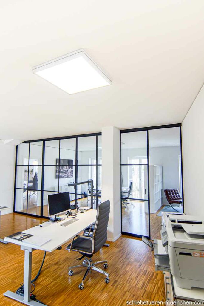Ein Großes Büro wird bei Bedarf von Schwarzen Schiebetüren mit Glas Füllung und Sprossen im Loft style Schallhemmend in zwei Bereiche unterteilt. Maßanfertigung von Door360 München (2)