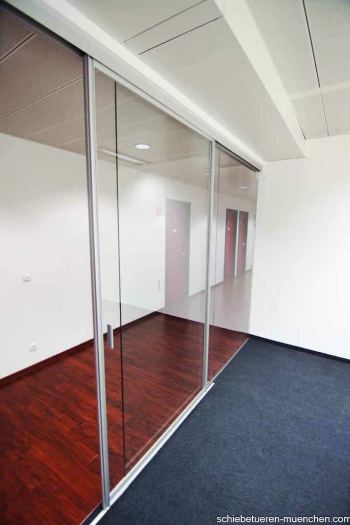 Büro Flur mit Großem Durchgang zu einem Arbeitsplatz. Dieser kann mit einer Schiebetüre aus Klarglas und einer Festverglasung abgetrennt werden. Maßgefertigt von Door360 München (2)