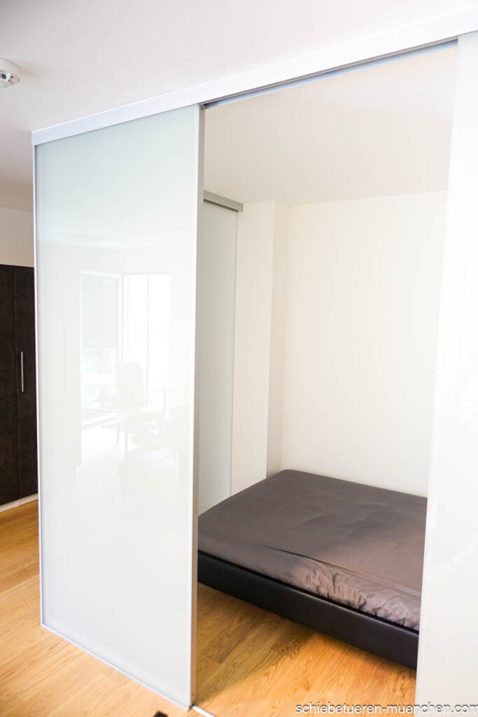Milchglas-Kubus: Schafft einen separaten Raum im Raum für ein Schlafzimmer. Das Schlafzimmer ist ausgestattet mit Milchglas-Festverglasung und einer Schiebetür von Door360 in München.
