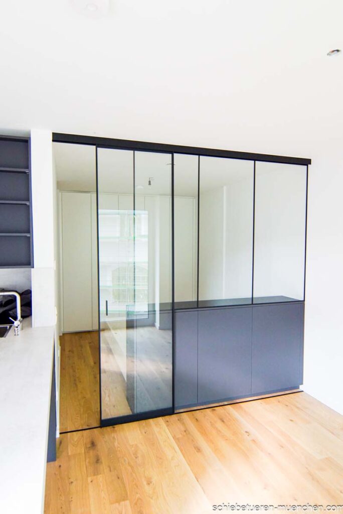 Raumteiler für ein Studio Apartment. Mit Hilfe von Schrank Festverglasung und Schiebetüren werden Wohn- und Schlafbereich dichtschließnd von einander abgetrennt