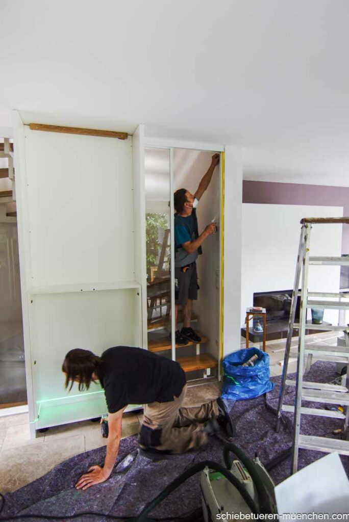 Team von Door360 bei der Installation eines Einbauschranks mit Schiebetüren zur Abtrennung eines offenen Treppenhauses.