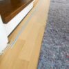 Einflügelige Loft-Schiebetür aus Klarglas mit weißem Rahmen, als elegante Treppenhaus-Abtrennung montiert.
