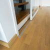 Einflügelige Loft-Schiebetür aus Klarglas mit weißem Rahmen, als elegante Treppenhaus-Abtrennung montiert.