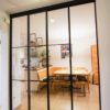 Loft-Schiebetür mit schwarzem Aluminiumrahmen und Sprossen im Industrie-Look, als Raumabtrennung zwischen Flur und Essbereich.
