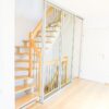 Mehrflügelige Schiebetür aus Klarglas mit silbernem Aluminiumrahmen, als Treppenhaus-Abtrennung mit Schallschutz und Rundumdichtung.