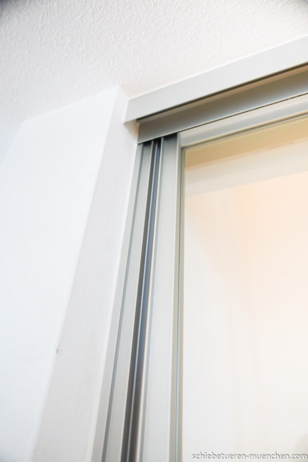 Mehrflügelige Schiebetür aus Klarglas mit silbernem Aluminiumrahmen, als Treppenhaus-Abtrennung mit Schallschutz und Rundumdichtung.