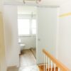 Badezimmer-Schiebetür aus satiniertem Milchglas, deckenmontiert, Blick vom Treppenhaus ins Bad