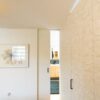 Badezimmer-Schiebetür aus Holz, flächenbündig in die Wand laufend – elegante Verbindung zwischen Schlafzimmer und Bad, München