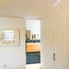 In die Wand eingelassene Holz-Schiebetür, Badezimmer-Design mit warmen Naturtönen