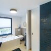 Moderne Holz-Schiebetür für das Badezimmer, flächenbündig in die Wand eingelassen – platzsparende Lösung mit natürlicher Optik