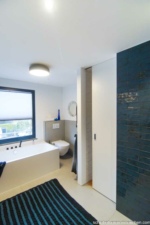 Moderne Holz-Schiebetür für das Badezimmer, flächenbündig in die Wand eingelassen – platzsparende Lösung mit natürlicher Optik