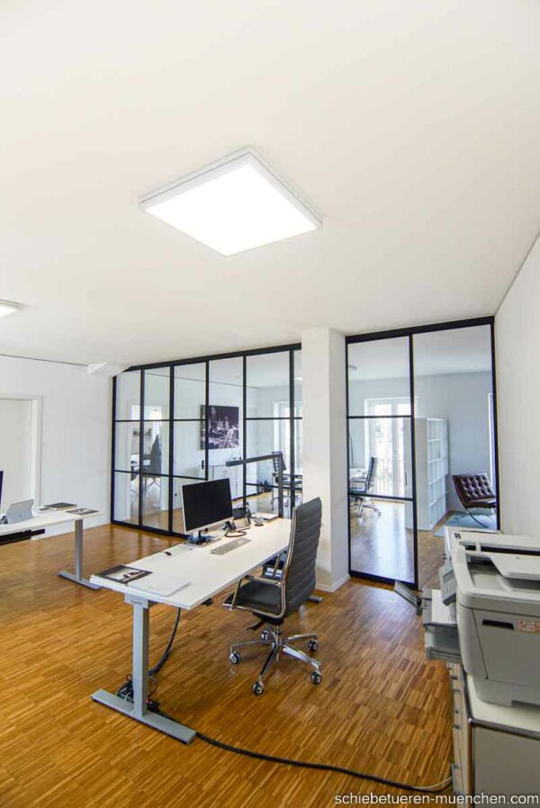 Raumteiler Schiebetürsystem von door360 – industrielle Optik mit schwarzen Sprossen, Büro München.