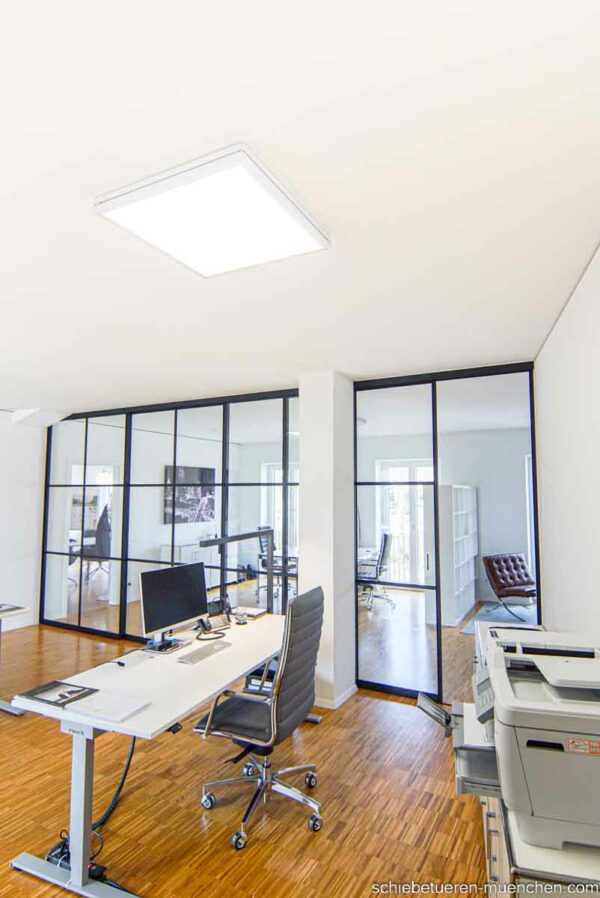 Büro-Raumteiler im Loftstil – schwarze Schiebetüren mit Sprossen von door360, offene Arbeitsbereiche strukturieren.