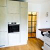 Moderne Glasschiebetür im Industrie-Look mit Sprossen, Profilfarbe Anthrazit, zwischen Küche und Wohnzimmer.