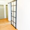 Schlanke Glasschiebetür mit anthrazitfarbenen Profilen und Sprossen, klare Verglasung, harmonische Lösung zwischen Küche und Wohnbereich.