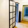 Schiebetür aus Glas mit anthrazitfarbenem Sprossenrahmen, VSG Klarglas, als moderner Raumteiler Küche-Wohnzimmer.