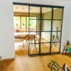 Raumhohe Loft-Schiebetür im Industrie-Look mit Sprossen, als moderne Abtrennung zwischen Wohn- und Esszimmer