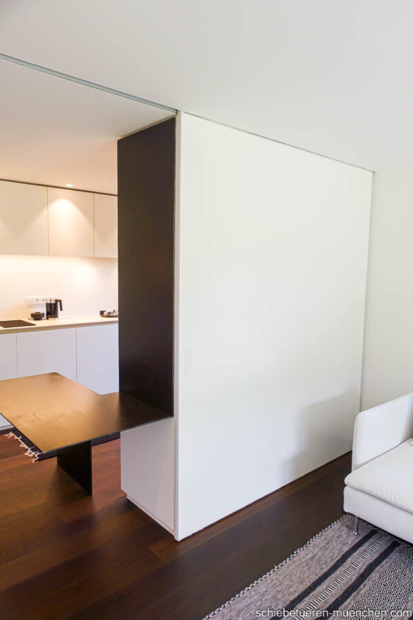 Eleganter Raumteiler – Küche mit Wohnbereich durch eine große weiße Schiebetür verbunden, modernes Design