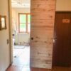 Schiebetür aus Altholz-Eiche im Badezimmer, geöffnet zur Badewanne, Deckenmontage mit schwarzer Laufschiene.